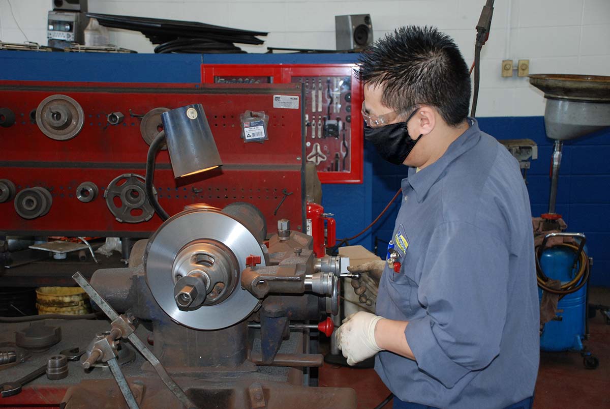 Matthews Tire employee resurfacing a brake rotor