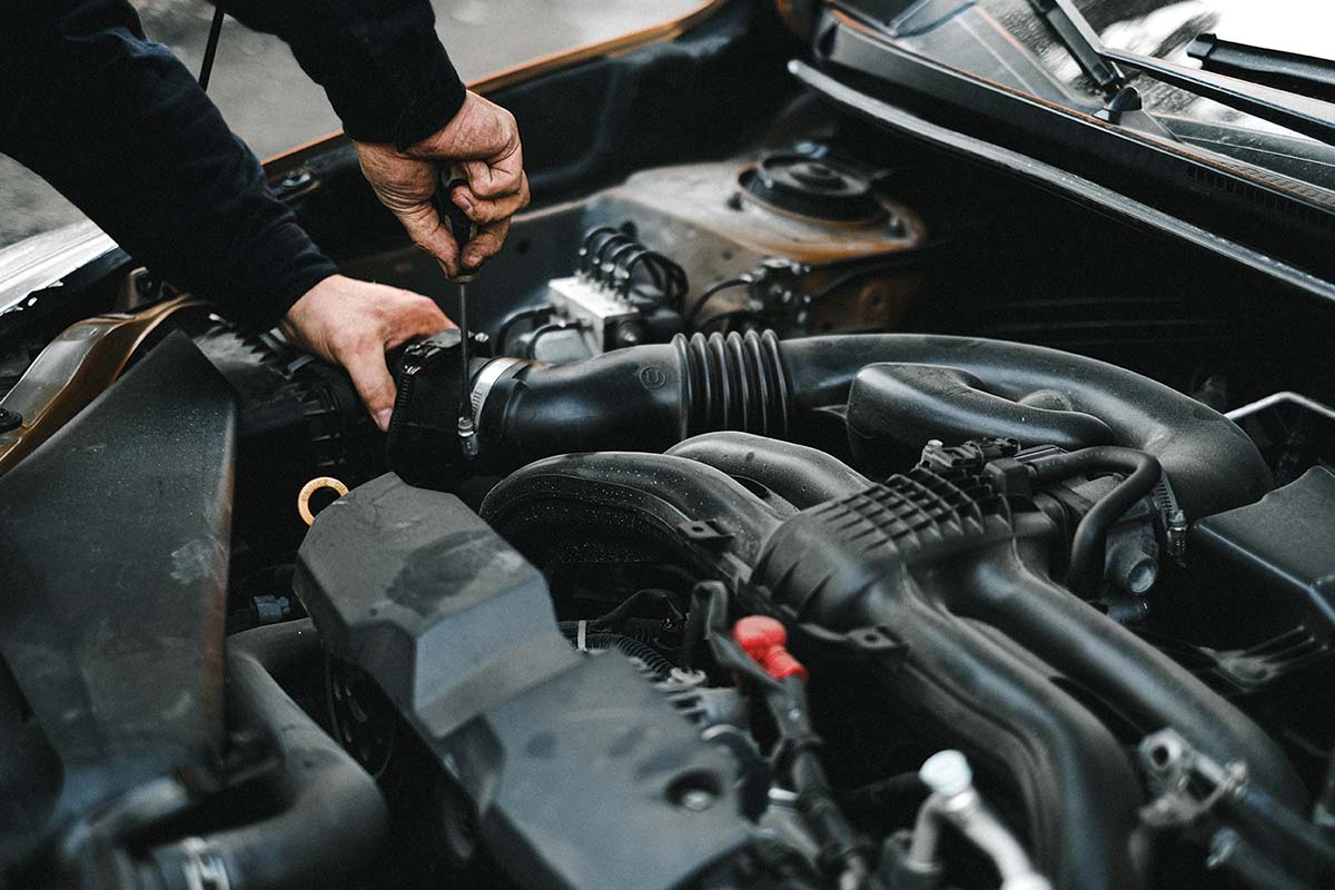 Matthews Tire employee working on changing out a vehicles air filter