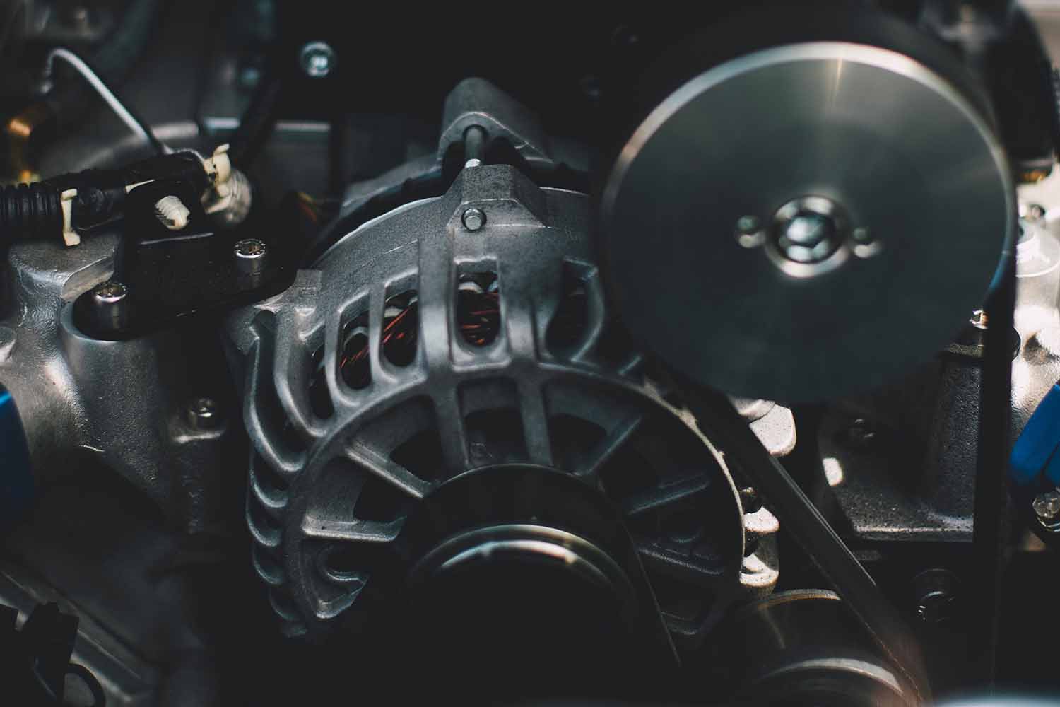 Close up look of an alternator inside an engine bay