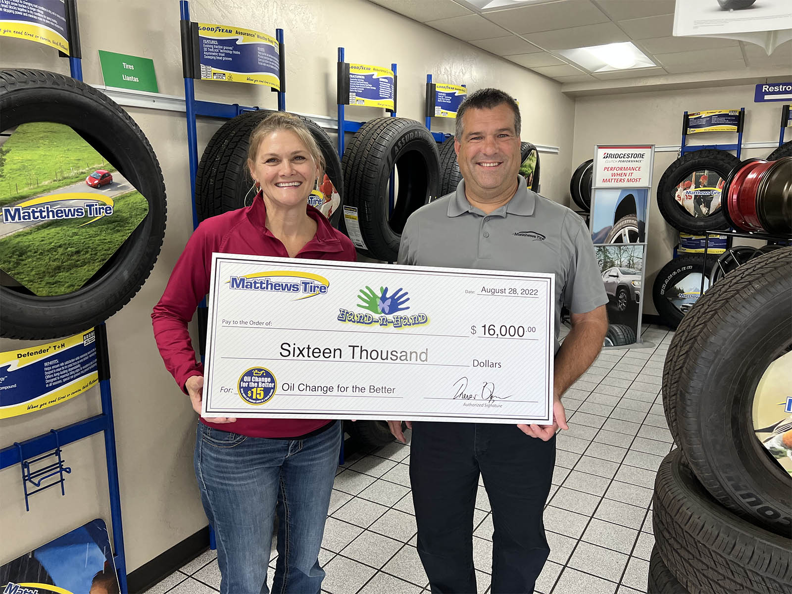 Matthews Tire President Trevor Reznor presents check to Hand-N-Hand