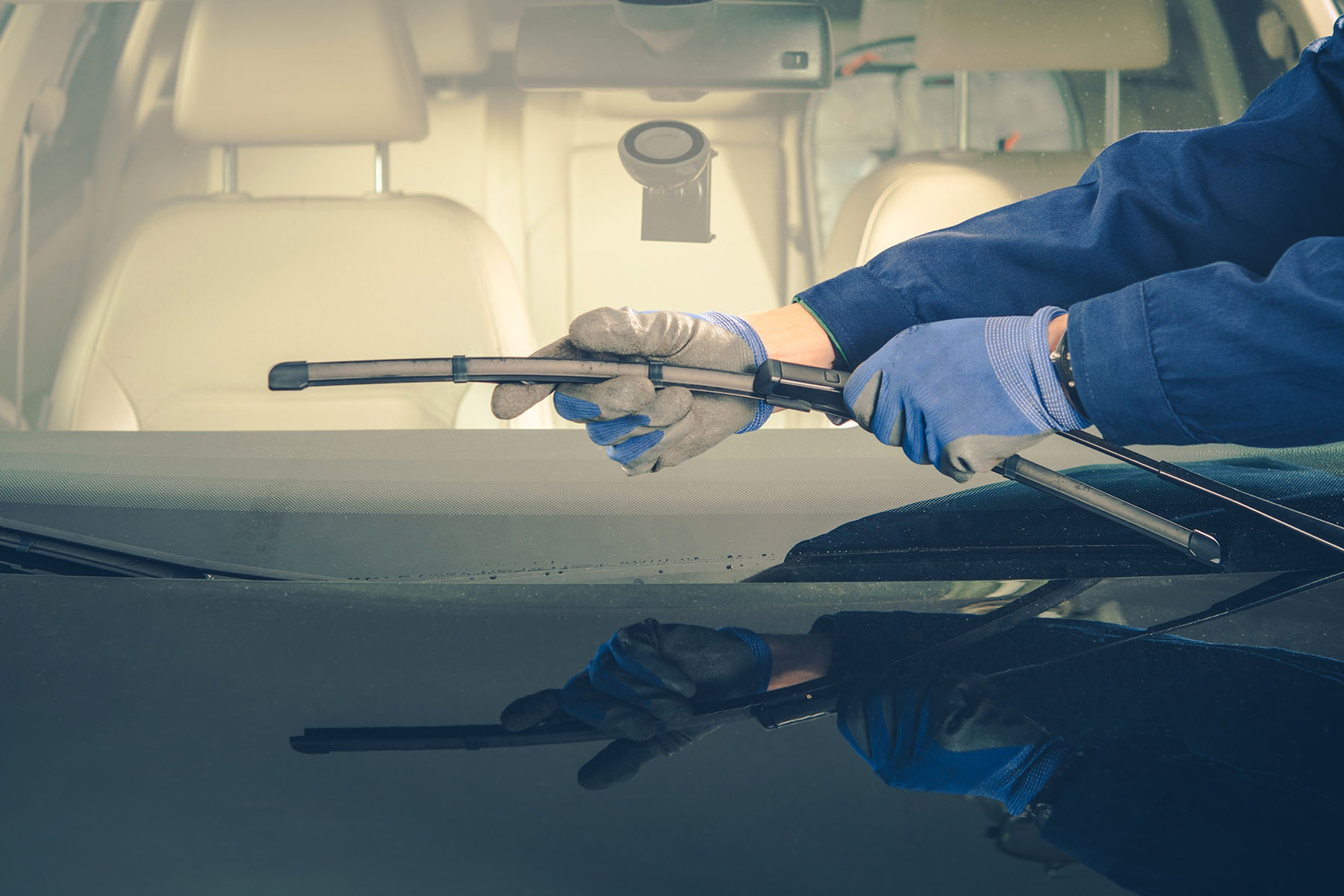A technician changing windshield wipers on a vehicle