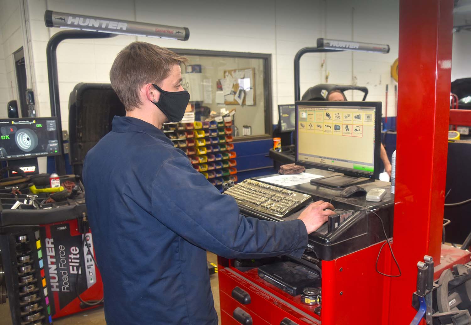 Matthews Tire employee working on computer while doing a wheel alignment