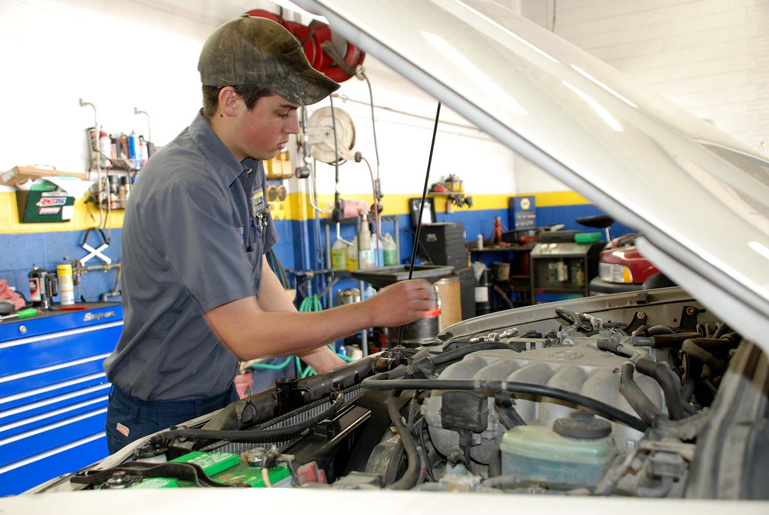 Matthews Tire ASE-certified Technician Changing Coolant on Vehicle