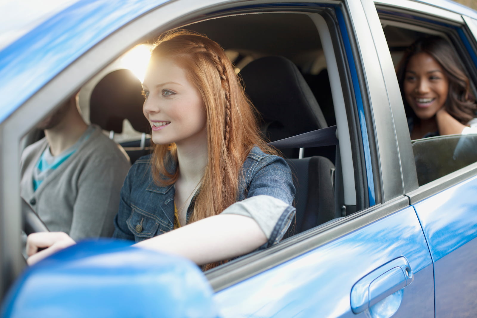 Yound woman driving car with friends