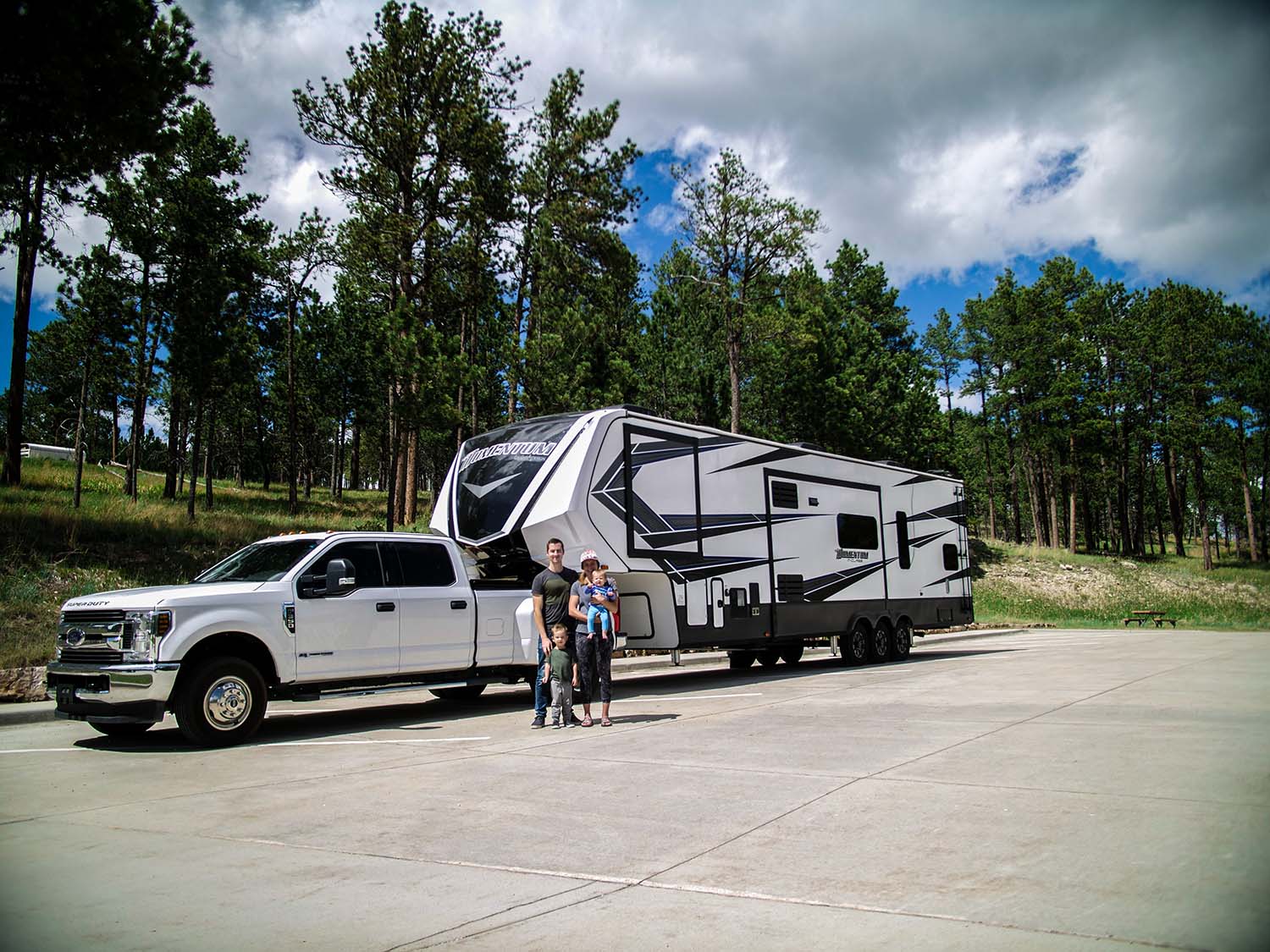 Family standing in front of truck and camper