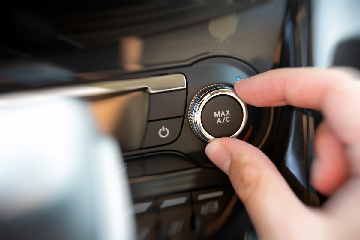 Person setting car air condition to max