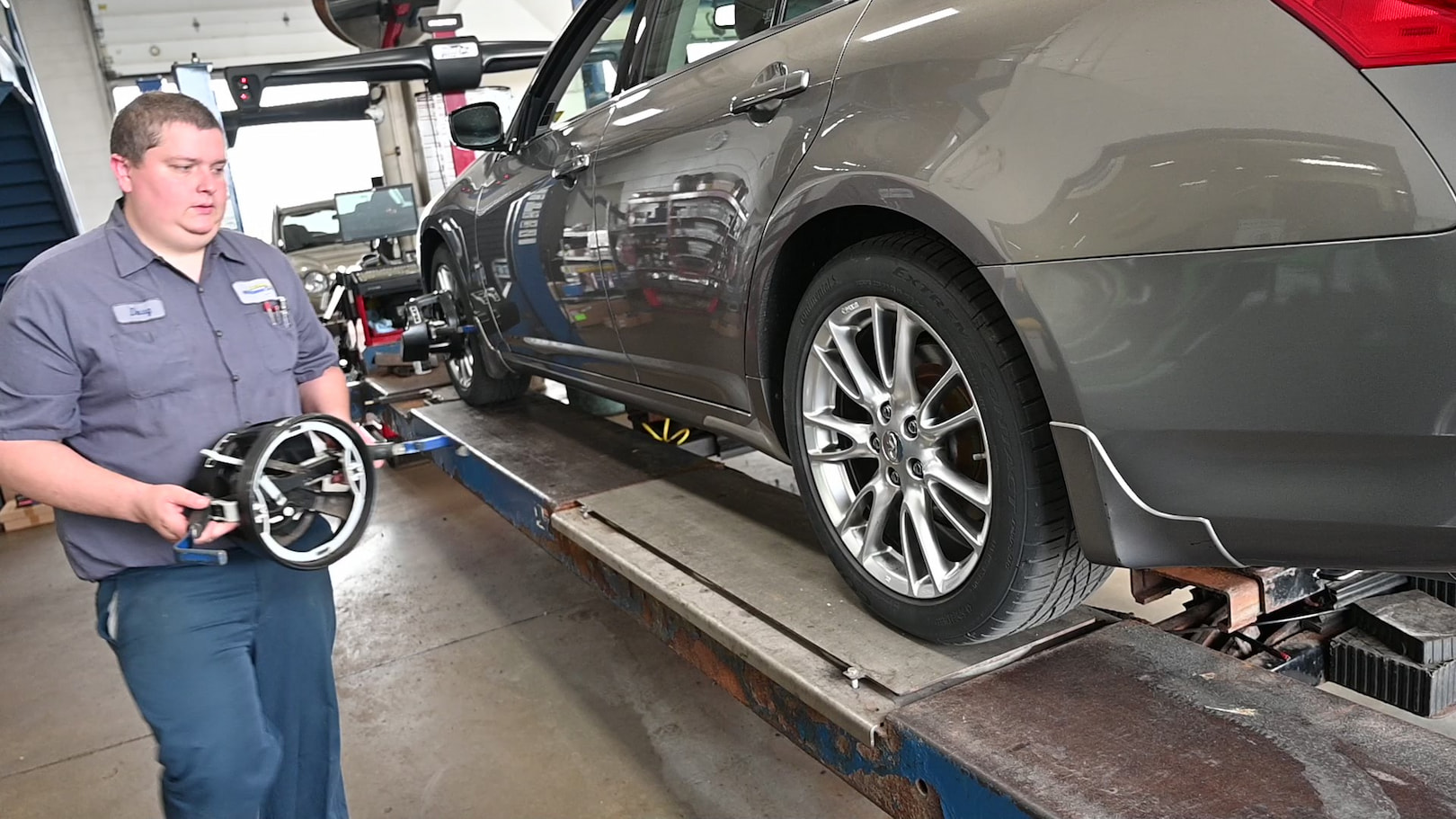 Technician removing alignment tool after wheel alignment service in Menasha, WI.