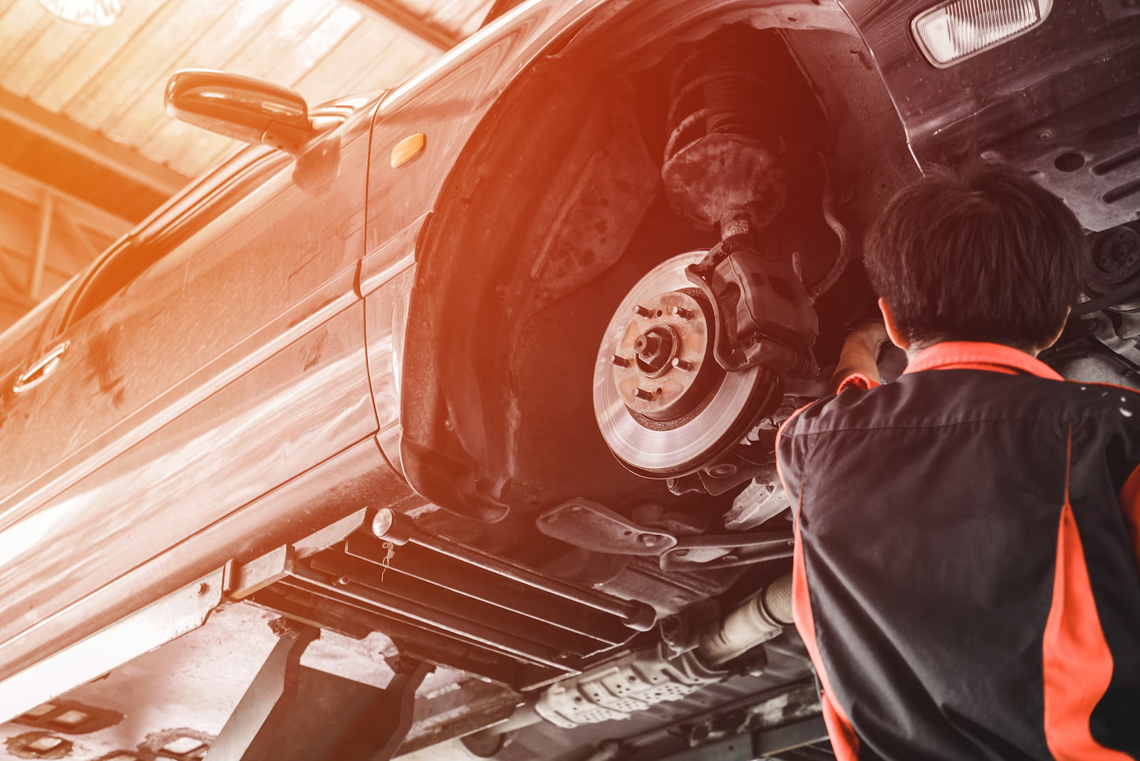 Automotive technician replacing brakes on vehicle