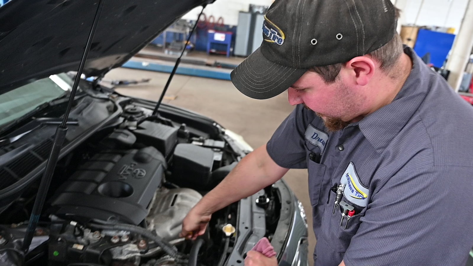 Mechanic inspecting engine components during car AC repair service in Appleton, WI.