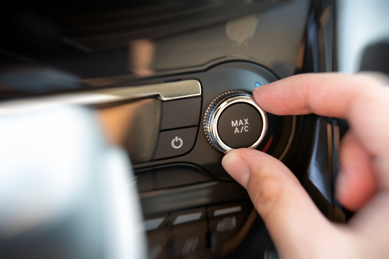 Driver turning on max AC setting during hot weather car AC use in Waupaca, WI.