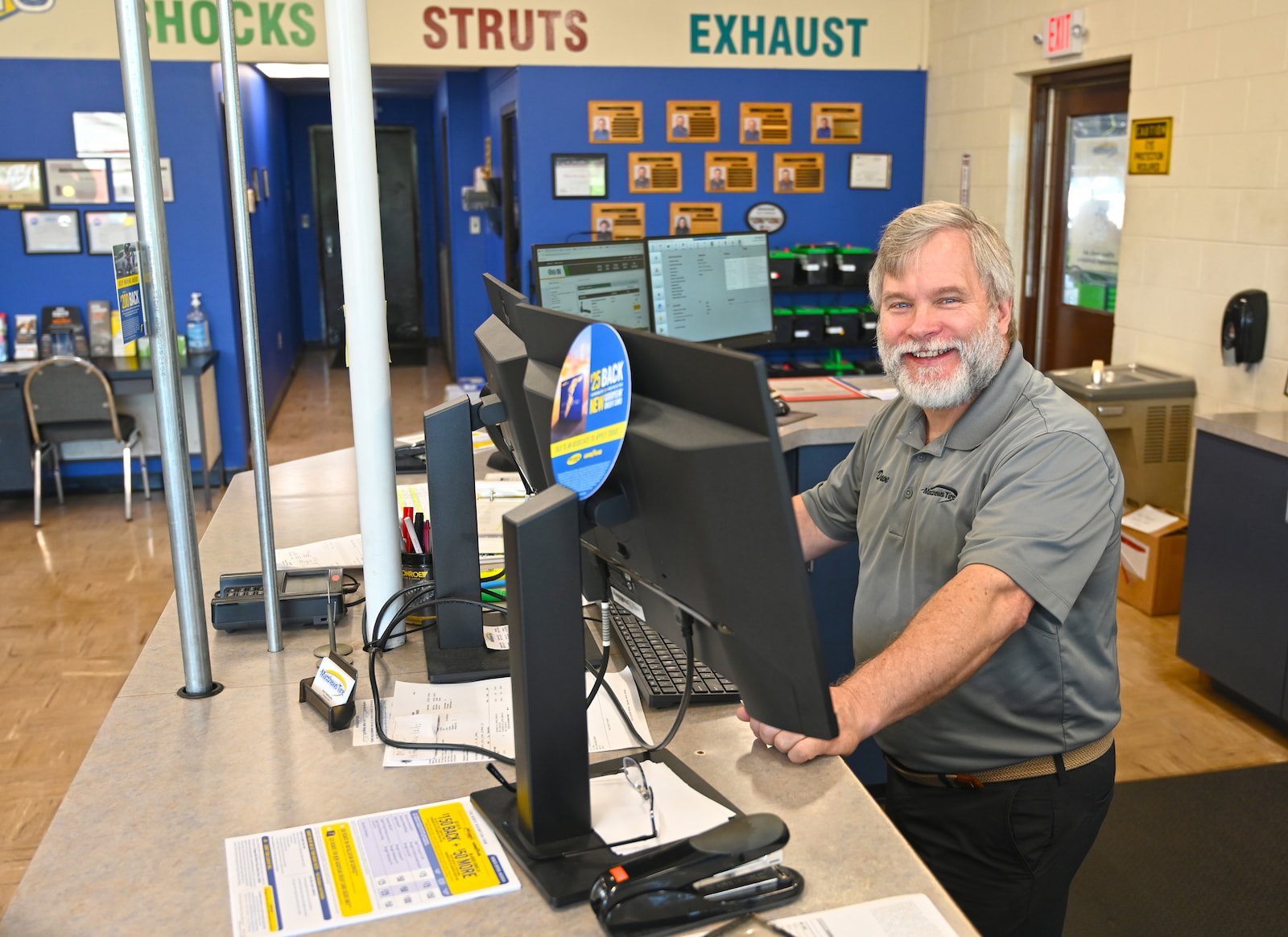 Friendly staff member assisting customers at Matthews Tire front desk in Fond du Lac, WI.