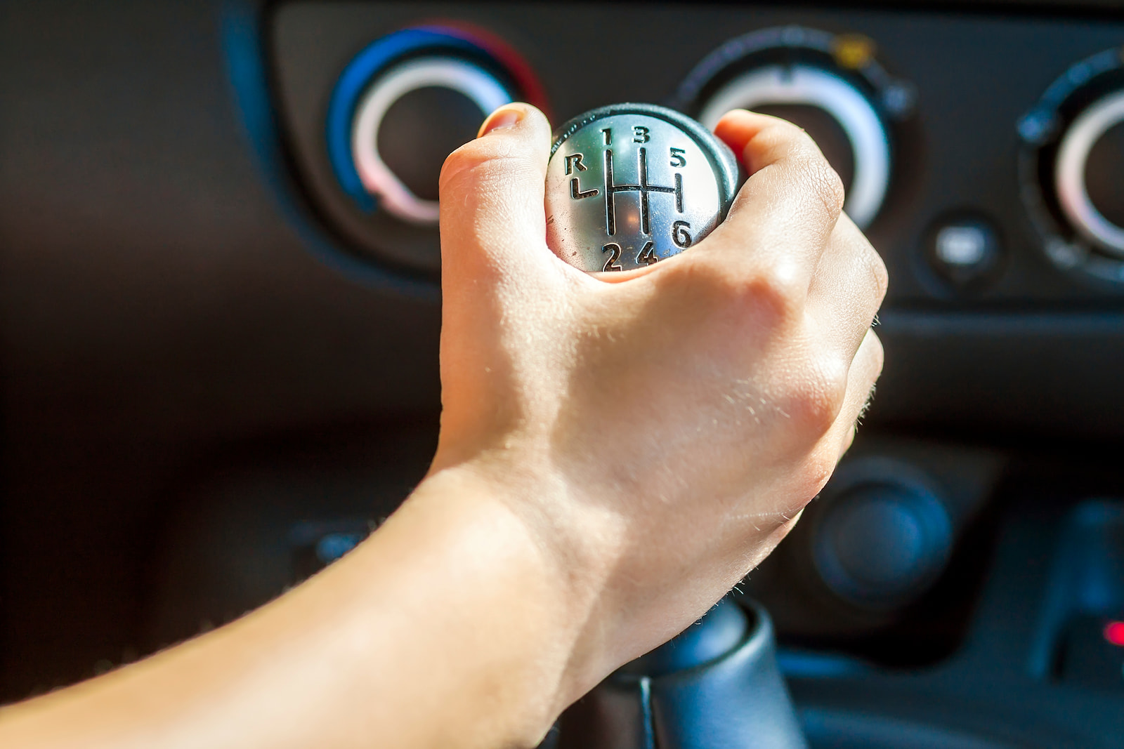 Driver hand on manual gear shifter during transmission inspection in Menasha, WI.