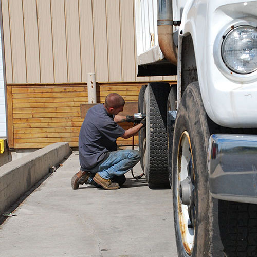 Matthews Tire technician working on large truck at the commercial tire center