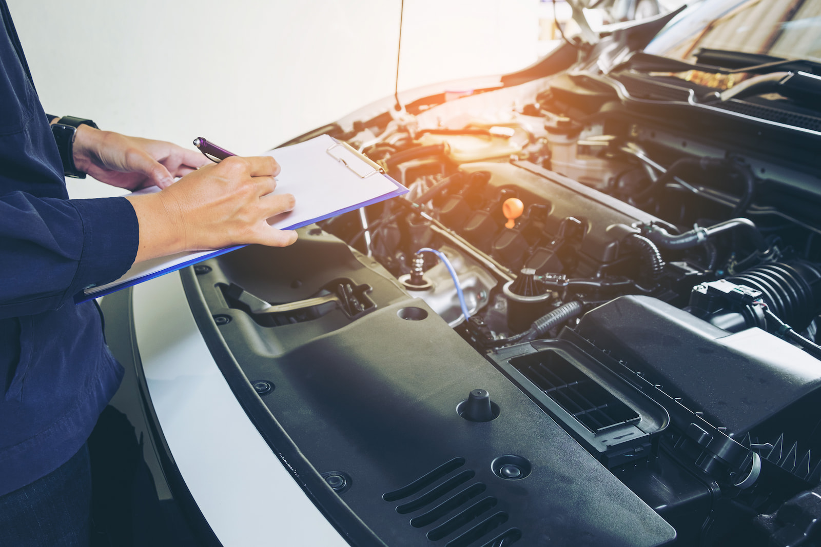 Technician recording vehicle inspection notes during an oil change service in Waupaca, WI.