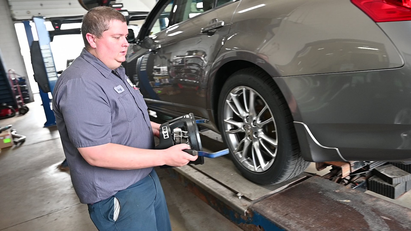 Matthews Tire technician removing alignment tool after wheel alignment in Waupaca, WI.