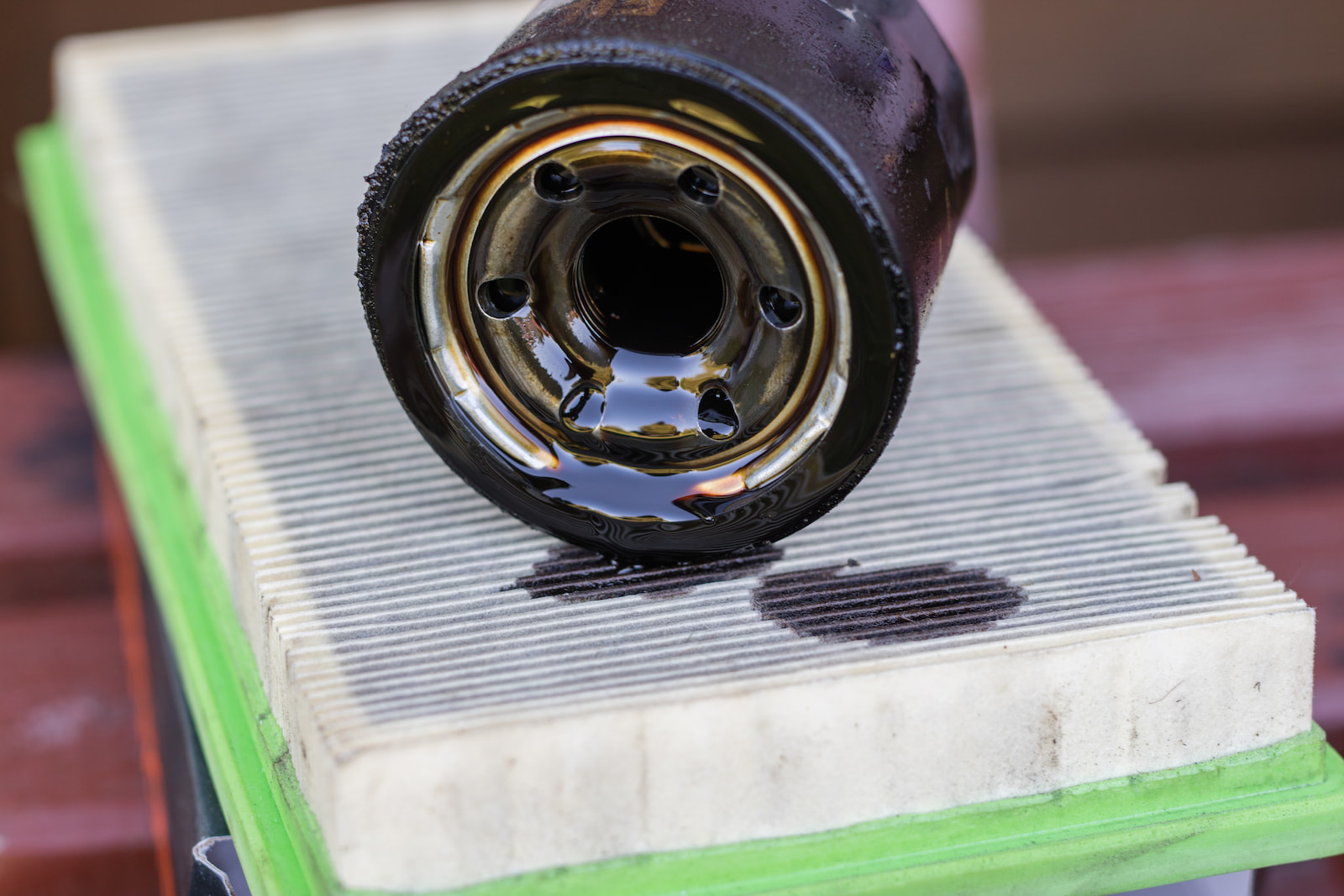 Dirty used oil filter resting on an air filter during vehicle maintenance in Waupaca, WI.