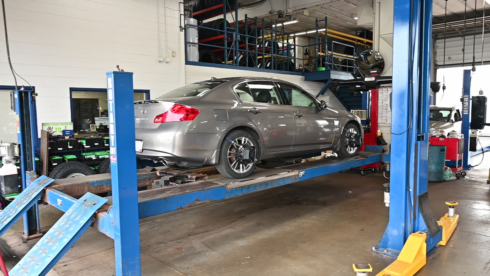 Sedan on lift at Matthews Tire undergoing wheel alignment in Appleton, WI.